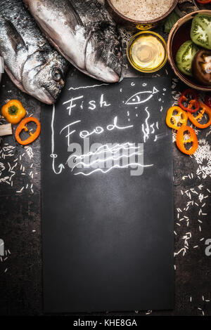 La nourriture de poisson sur tableau noir avec des poissons et des légumes sains dorado et ingrédients riz, vue de dessus, border , copy space Banque D'Images