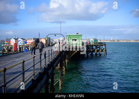 Deux vieillards marchant sur Southend Pier. Southend on Sea, Essex. Cabanes colorées Banque D'Images