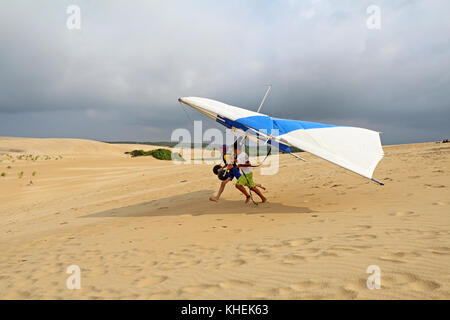 Nags Head, Caroline du Nord - le 29 juillet 2013 : élève prépare à décoller avec un instructeur de la Kitty Hawk kites hang gliding school sur le sable du Banque D'Images