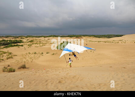 Nags Head, Caroline du Nord - le 29 juillet 2013 : étudiant vole avec un instructeur de la Kitty Hawk kites deltaplane école sur les dunes de sable de jockey Banque D'Images