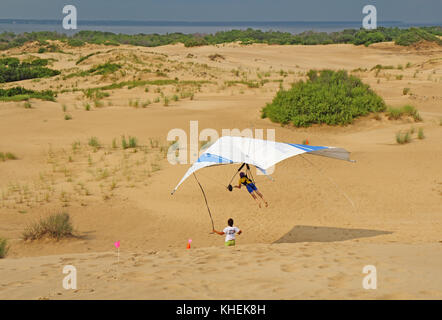 Nags Head, Caroline du Nord - le 29 juillet 2013 : étudiant vole avec un instructeur de la Kitty Hawk kites deltaplane école sur les dunes de sable de jockey Banque D'Images