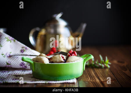 Sweet quenelles avec les cerises dans un bol sur une table en bois Banque D'Images