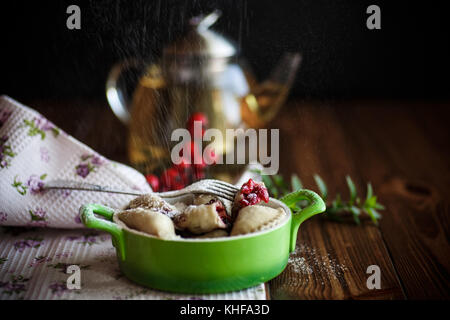 Sweet quenelles avec les cerises dans un bol sur une table en bois Banque D'Images