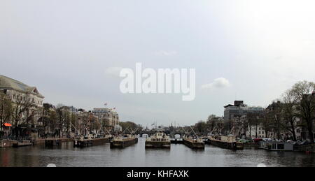 Amsterdam en avril 2016. aux Pays-Bas. grand canal avec des péniches et des vannes. Banque D'Images