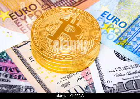 Pile de bitcoins doré sur les billets en euros et en dollars. financial concept moderne de devises. Banque D'Images