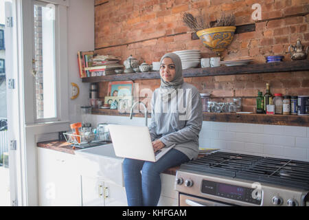 Femme musulmane de travailler à domicile sur son ordinateur portable Banque D'Images