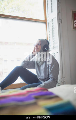 Femme musulmane portant un hijab à écouter de la musique Banque D'Images