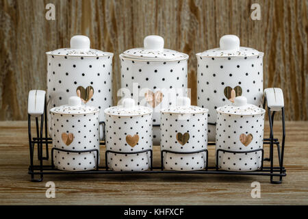 En porcelaine blanche pointillée noire spice jars avec motif coeur sur fond brun Banque D'Images