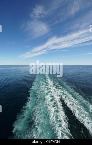 Service du navire spectaculaire qui s'étend en diagonale à l'horizon sous un ciel bleu avec des nuages blancs whispy. Banque D'Images