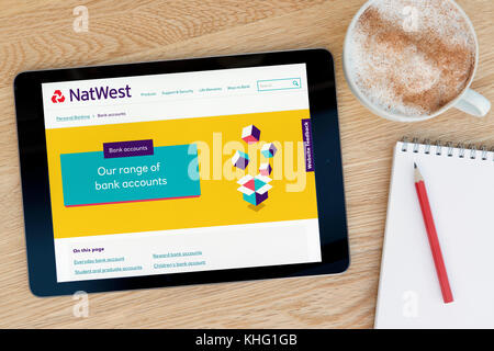 Le site web dispose d'un sur Natwest iPad tablet device qui repose sur une table en bois à côté d'un bloc-notes et un crayon et une tasse de café (rédaction uniquement) Banque D'Images