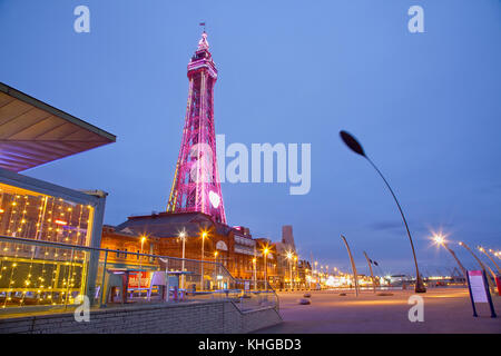 L'Angleterre, dans le Lancashire, Blackpool, promenade du front de mer avec tour illuminée au crépuscule. Banque D'Images