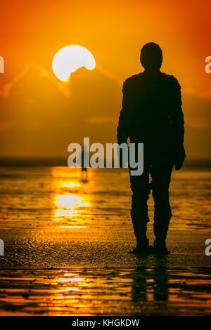 Crosby, Merseyside. Coucher de soleil sur Crosby. 16 novembre 2017. Météo britannique. Après une journée glaciale, sur la côte nord-ouest de l'Angleterre, un superbe coucher du soleil tombe dans l'horizon pour créer des silhouettes de Sir Antony Gormley est "un autre endroit" Iron Men art installation sur les rives du Crosby Beach dans le Merseyside. "Un autre endroit" se compose de 100 fonte, life-size figures réparties le long de trois kilomètres de l'estran, qui s'étend près d'un kilomètre au large. Credit : Cernan Elias/Alamy Live News Banque D'Images