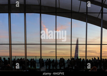 Londres, Royaume-Uni. 17 novembre 2017. Météo britannique. Les gens sur le bâtiment Walkie Talkie, 20 Fenchurch Street, plate-forme d'observation s'alignent le long de la terrasse et fenêtres panoramiques pour regarder le coucher du soleil. Un beau coucher de soleil conclut une journée froide mais très ensoleillée dans la capitale britannique avec un ciel dégagé au-dessus de Londres. Crédit : Actualités Imageplotter et Sports/Alamy Live News Banque D'Images