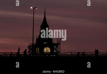 Vendredi 17 novembre 2017. Londres en Angleterre. Londres est accueilli avec un magnifique coucher de soleil pour marquer la fin de vendredi que les banlieusards sont sans travail et arrêter de photographier le spectacle. La gent à droite images Elizabeth Tower( Big Ben) et enclenche une photo sur son téléphone mobile comme l'horloge des pics de l'échafaudage entourant la tour. Paul Watts/ Alamy live news Banque D'Images