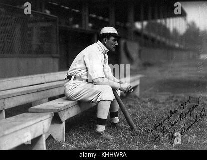 Napoleon Lajoie, joueur de deuxième base de baseball professionnel américain et joueur-entraîneur qui a joué pour les Philadelphia Phillies, Philadelphia Athletics (deux fois), et Cleveland Naps, assis sur un banc avec sa batte, l'image est inscrite 'Copyright 1908 by l Van Oeyen, Cleveland, Ohio', 1908. De la Bibliothèque publique de New York. Banque D'Images