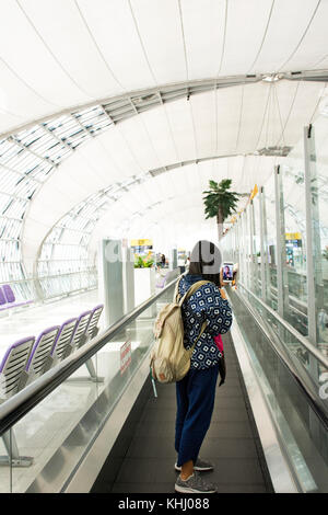 Les femmes thaïlandaises voyageur smartphone utiliser prendre photo avec billet et passeport à l'aéroport international Suvarnabhumi de Bangkok, Thaïlande. Banque D'Images