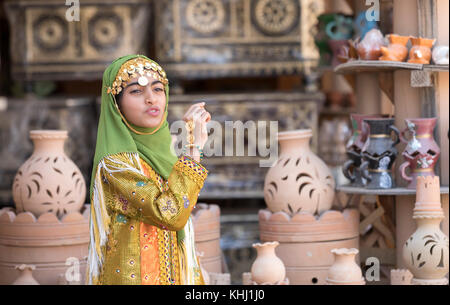 Nizwa, Oman, Novembre 10th, 2017 : jeune fille habillée de façon traditionnelle omanaise vêtements chanter Banque D'Images