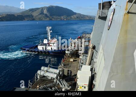 Un remorqueur aide la classe Arleigh Burke destroyer lance-missiles USS Po Banque D'Images