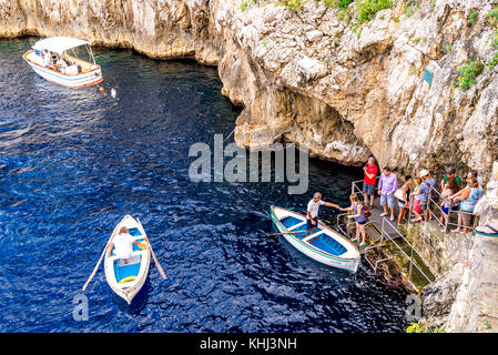 Une ligne de touristes attendent pour leur promenade en bateau dans la célèbre Grotte bleue sur l'île de Capri en Italie Banque D'Images