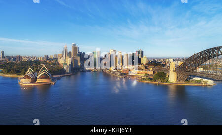 Monuments de la ville de Sydney CBD sur harbor waterfront autour de Circular Quay à l'arche du pont du port de sydney en lumière chaude du soleil du matin bleu sous Banque D'Images