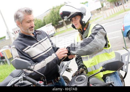 Aider à mettre un gants moto Banque D'Images