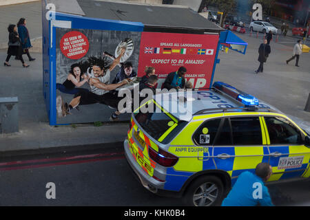 A rencontré les agents de police question un homme à côté de l'affiche de Stomp, le West End production musicale, le 13 novembre 2017, à London Bridge, à Londres, en Angleterre. Banque D'Images