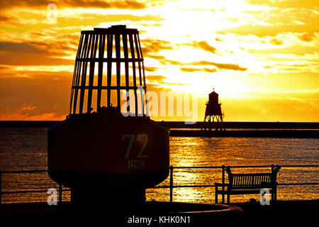 Bouée de North Shields avec le phare d'époque de South Shields Herd Sands sur la groyne au lever du soleil Banque D'Images