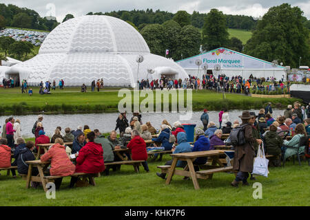 Grande foule à Chatsworth RHS Flower Show - assis à des tables de pique-nique, d'entrer dans de grandes tentes blanches - Chatsworth House, Derbyshire, Angleterre, Royaume-Uni. Banque D'Images