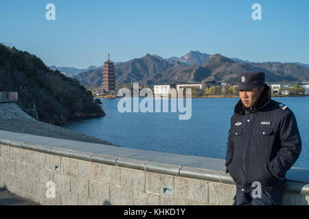 Un garde de sécurité est en service le long du lac yanqi à Huairou, Beijing, Chine. Banque D'Images