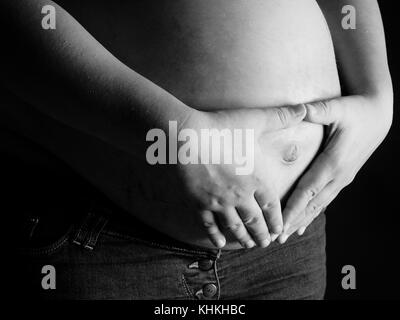 La femme tenant le ventre d'une femme enceinte Banque D'Images