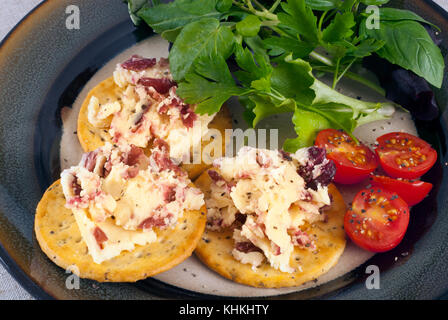 Après une délicieuse collation du fromage avec canneberges, biscuits, assaisonné avec des tomates cerises et de basilic. Still Life Studio shot. Banque D'Images