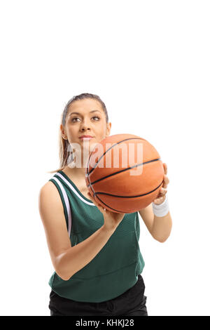 Jeune femme dans un maillot vert avec un terrain de basket-ball s'apprêtait à tourner isolé sur fond blanc Banque D'Images