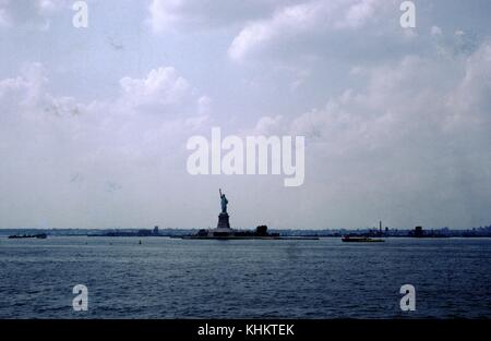 Statue de la liberté vue d'un bateau dans le port de New York un jour sombre et couvert, de loin, New York City, New York, 1965. Banque D'Images