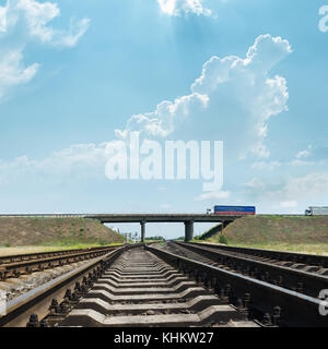 Railway va à horizon sous le pont avec autos Banque D'Images