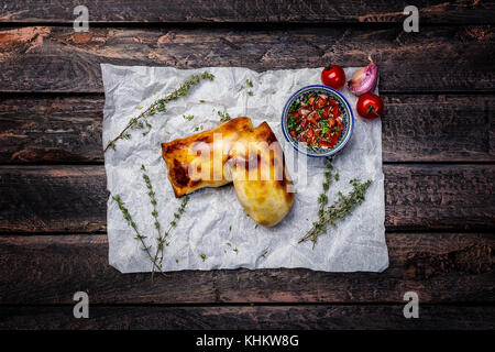 La cuisine asiatique. samsa avec sauce tomate et fines herbes. fond de bois. vue d'en haut. Banque D'Images