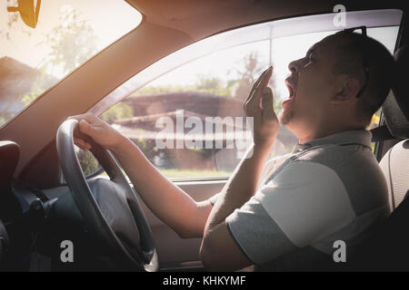 Le bâillement sleepy man driving car dans la circulation après de longues heures de route. l'homme s'endormir dans la voiture. Banque D'Images