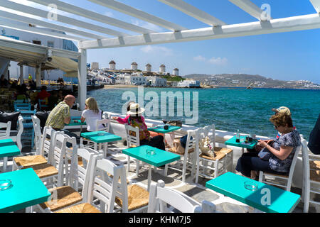 Restaurant et bars le long de la petite Venise avec vue sur les moulins à vent, l'île de Mykonos, Cyclades, Mer Égée, Grèce Banque D'Images