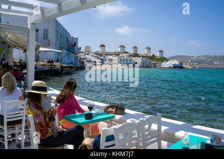 Restaurant et bars le long de la petite Venise avec vue sur les moulins à vent, l'île de Mykonos, Cyclades, Mer Égée, Grèce Banque D'Images