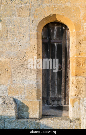 Petite porte en bois de chêne léger en à St Andrew's Church. Naunton, Cotswolds, Gloucestershire, Angleterre Banque D'Images