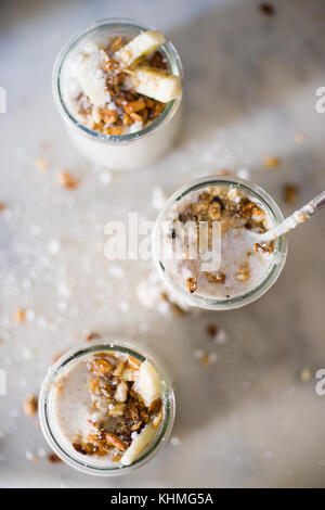 Oatmel yaourt avec chia seeds avec granola et morceaux de banane sur un fond de marbre dans une cuisine moderne Banque D'Images