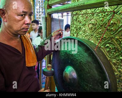 Yangon, région de Yangon, Myanmar. 18 novembre 2017. Un homme frappe un gong de prière à la pagode Botataung à Yangon. Le pape François est en visite au Myanmar du 27 au 30 septembre. Ce sera la première visite d’un pape à la nation majoritairement bouddhiste. Il rencontrera Aung San Suu Kyi et d'autres dirigeants politiques et participera à deux messes à Yangon. Le Pape devrait parler de la question des Rohingyas pendant son séjour au Myanmar. Les Rohingyas sont une minorité musulmane persécutée dans l’État de Rakhine, dans l’ouest du Myanmar. On ne sait pas très bien comment les moines nationalistes politiquement puissants du Myanmar réagiront si le pape ouvre Banque D'Images