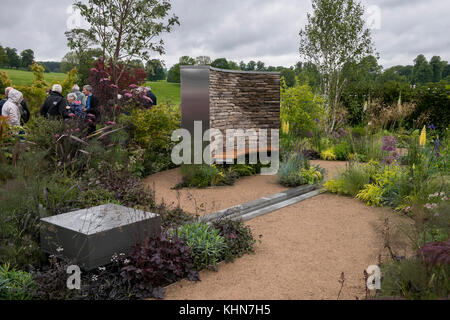 Visiteurs passent situation calme et isolée, coin salon et végétaux, dans un spectacle au jardin premier Chatsworth RHS Flower Show, Chatsworth House, Derbyshire, Angleterre, Royaume-Uni. Banque D'Images