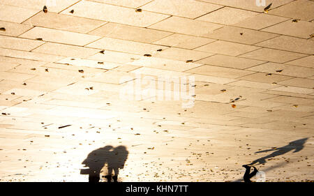 Silhouette d'ombre d'un peuple sur city square à motifs avec des feuilles mortes sépia Noir et blanc à l'envers Banque D'Images