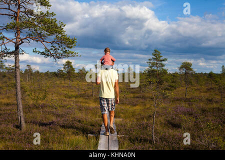 Homme marchant loin de caméra au-dessus de paysage incroyable avec un enfant assis sur ses épaules Banque D'Images