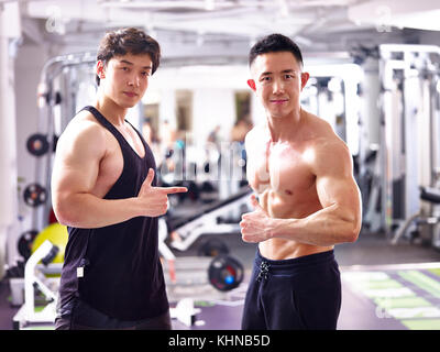 Deux bodybuilders asiatique posant dans sport montrant les muscles. Banque D'Images