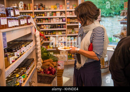 Une femme acheteuse au Cletwr Cafe and Community shop, propriété et gestion locale, Tre'R Ddol, Ceredigion Wales UK Banque D'Images