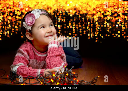 Portrait of cute little Girl with Christmas Tree on background Banque D'Images