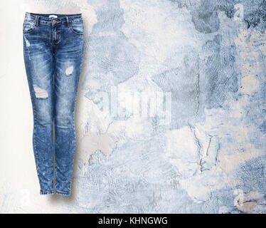 Jeans femme en lumière la lumière fond grunje with copy space Banque D'Images