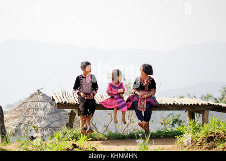 Beau garçon et fille jouant à l'extérieur tout en se posant le port de vêtements ethniques de la tribu Hmong, peuple autochtone de la Thaïlande. Banque D'Images