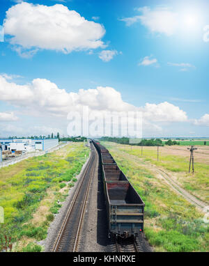 Wagons vides sur railroad sous les nuages dans le ciel bleu Banque D'Images